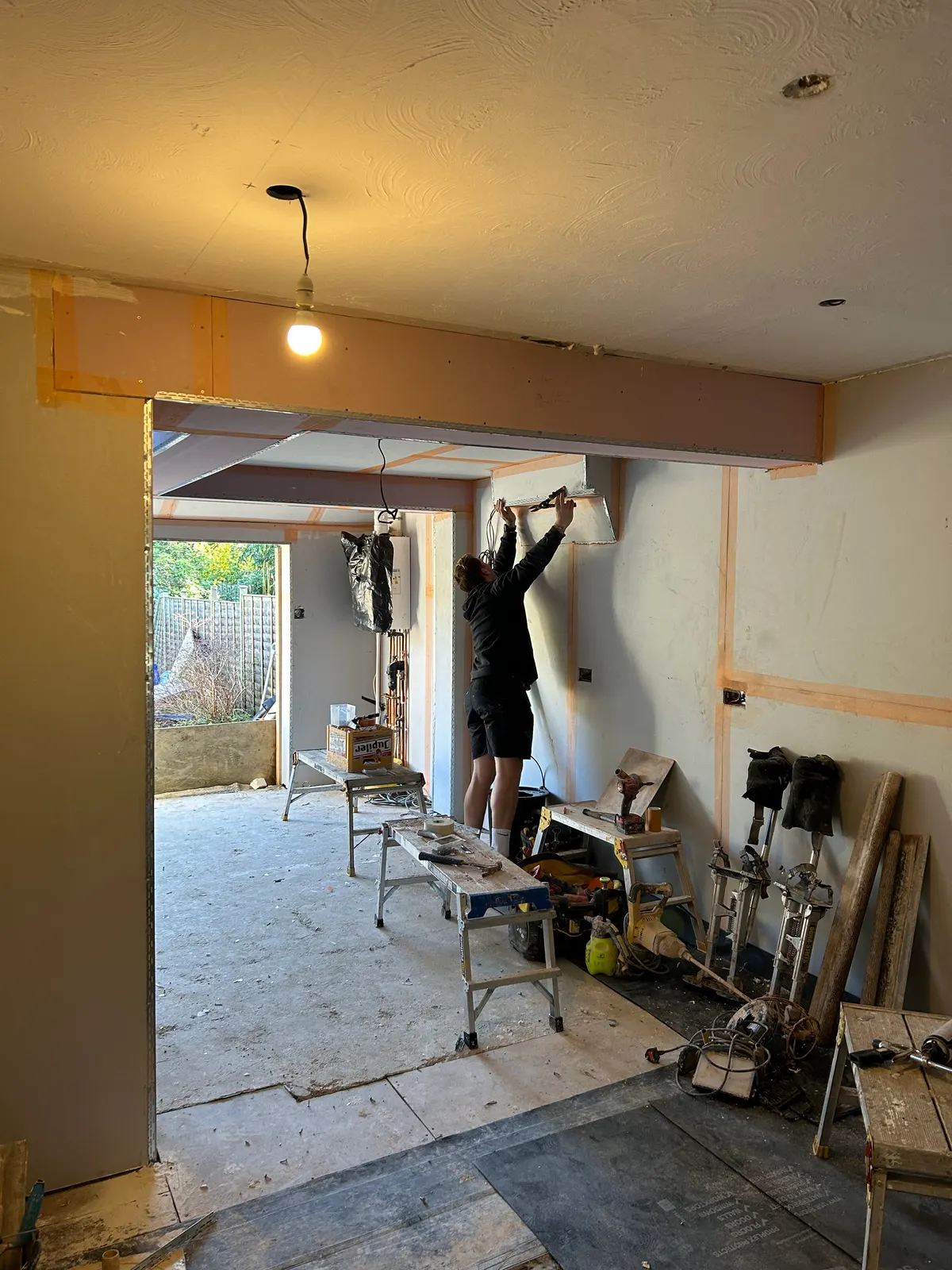 Hancock plasterer skimming a wall around a newly installed steel beam