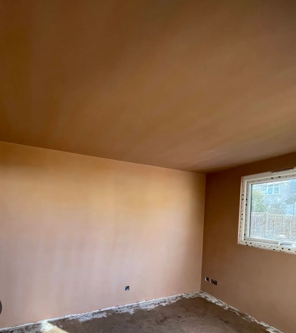 Smoothly skimmed ceiling and wall with a neat plastered window reveal