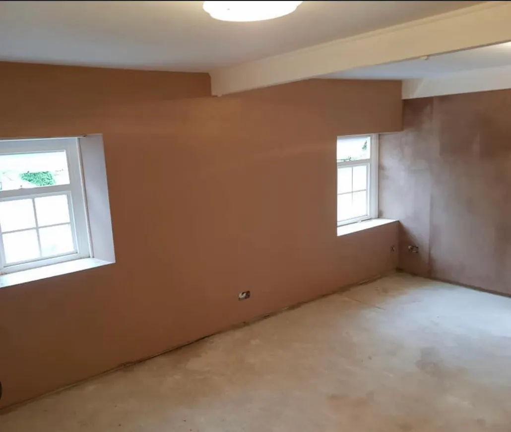 Freshly plastered bedroom walls between two windows