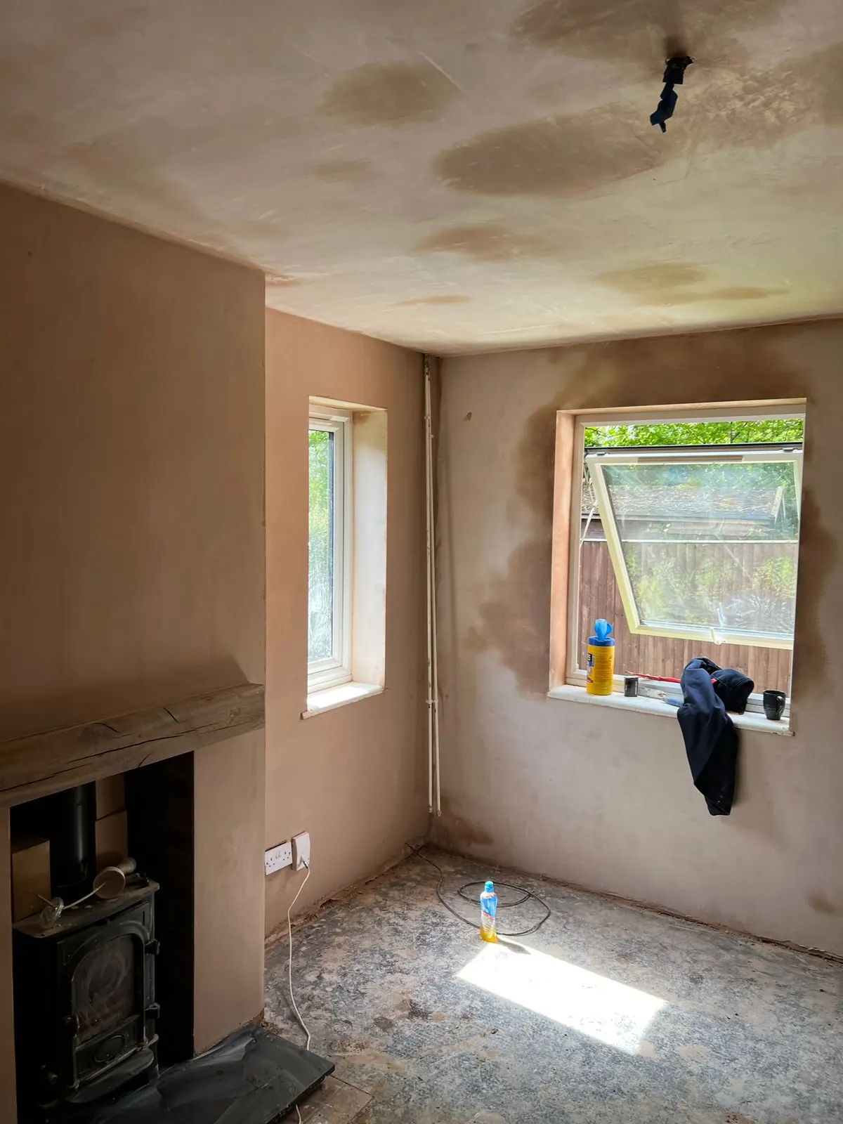 Freshly plastered living room walls around a wood-burning stove