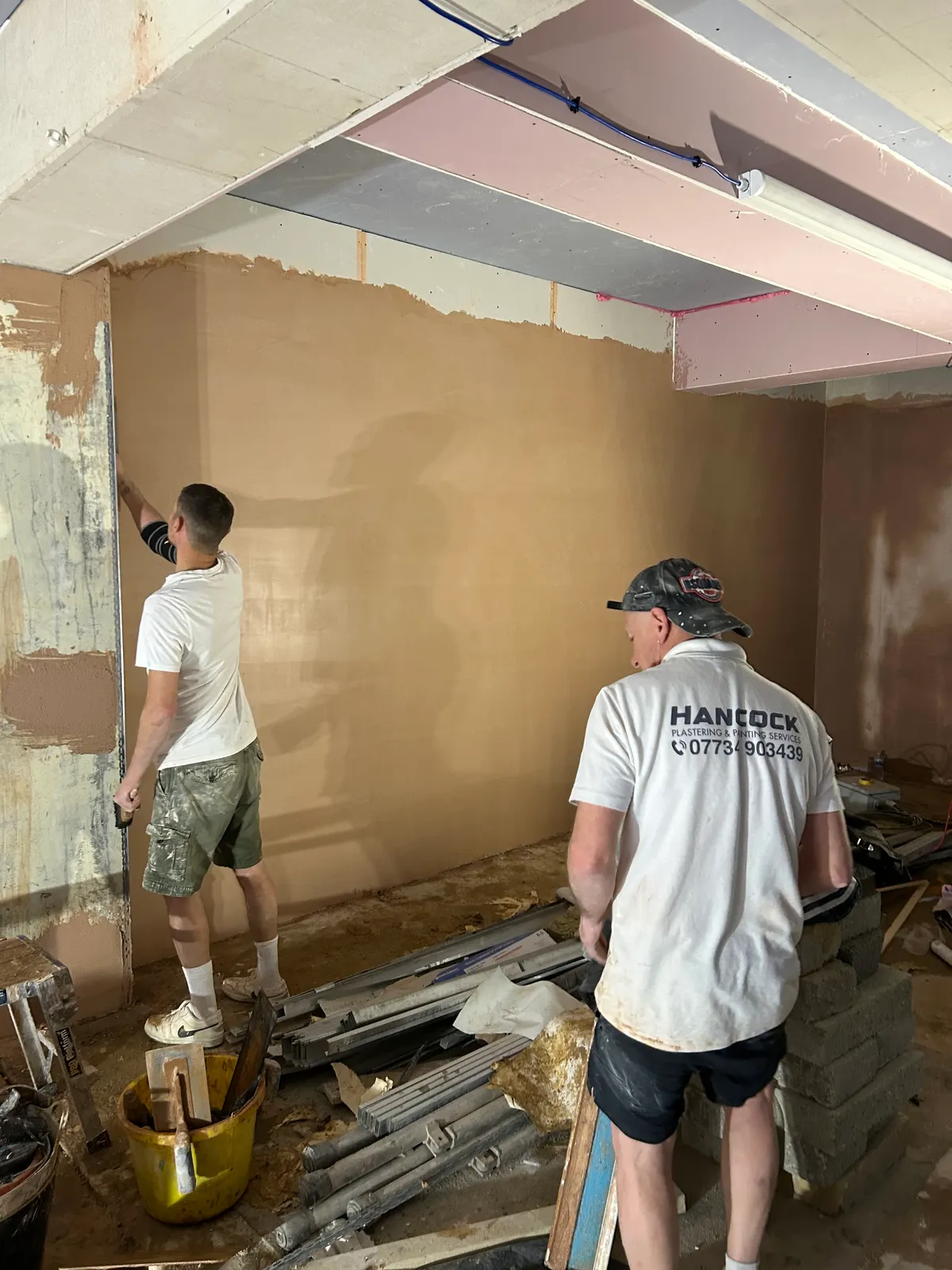 Hancock plastering team skimming a wall during a full renovation