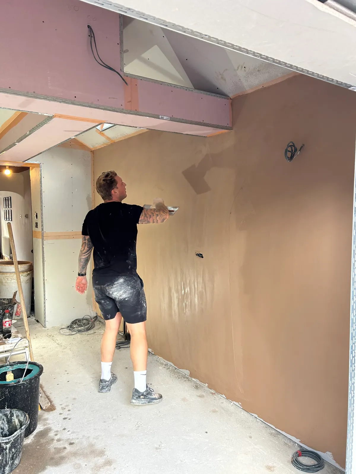 Hancock plasterer applying a smooth skim finish to an extension wall