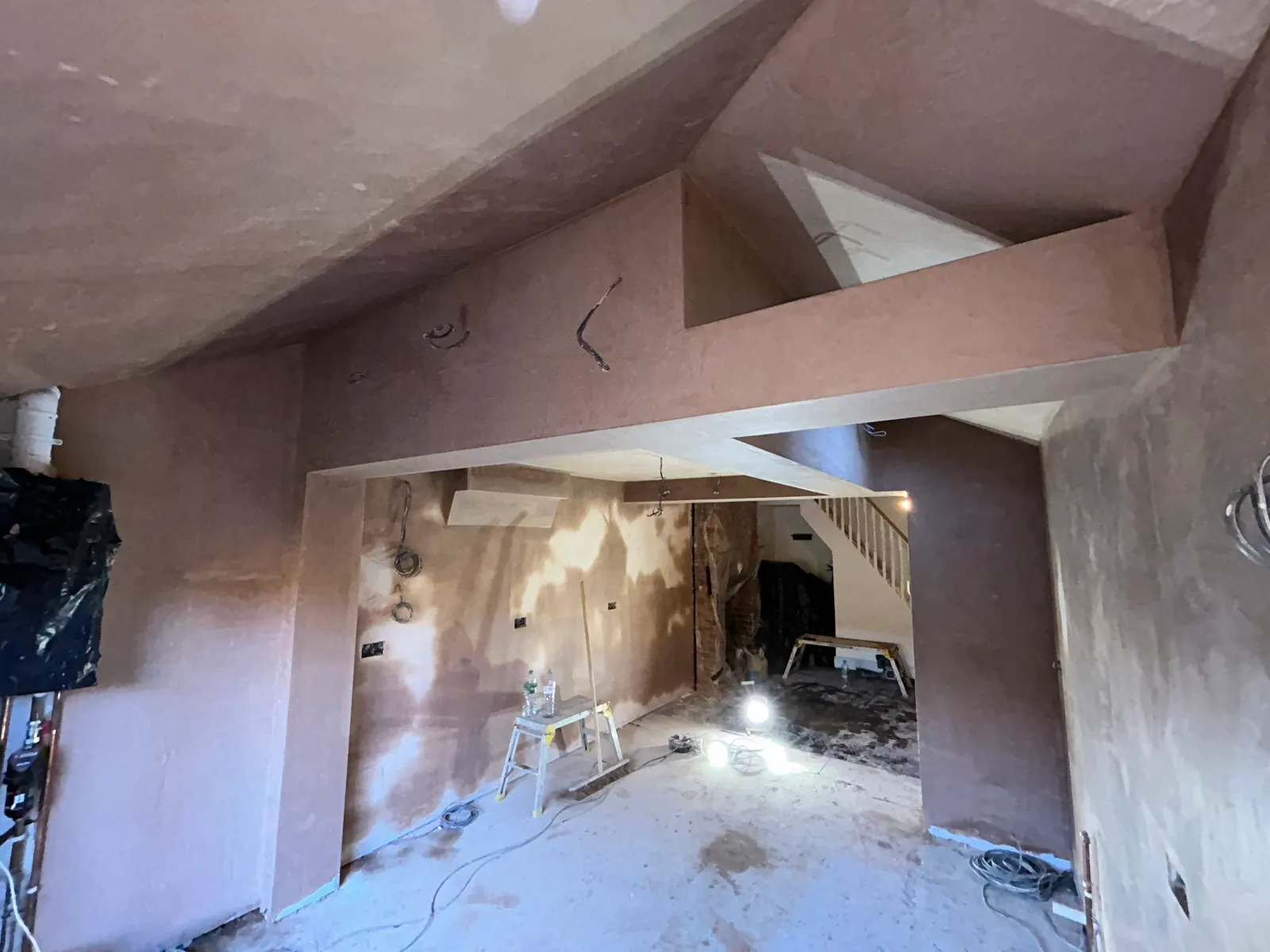 Freshly plastered walls and vaulted ceiling in an open-plan home renovation