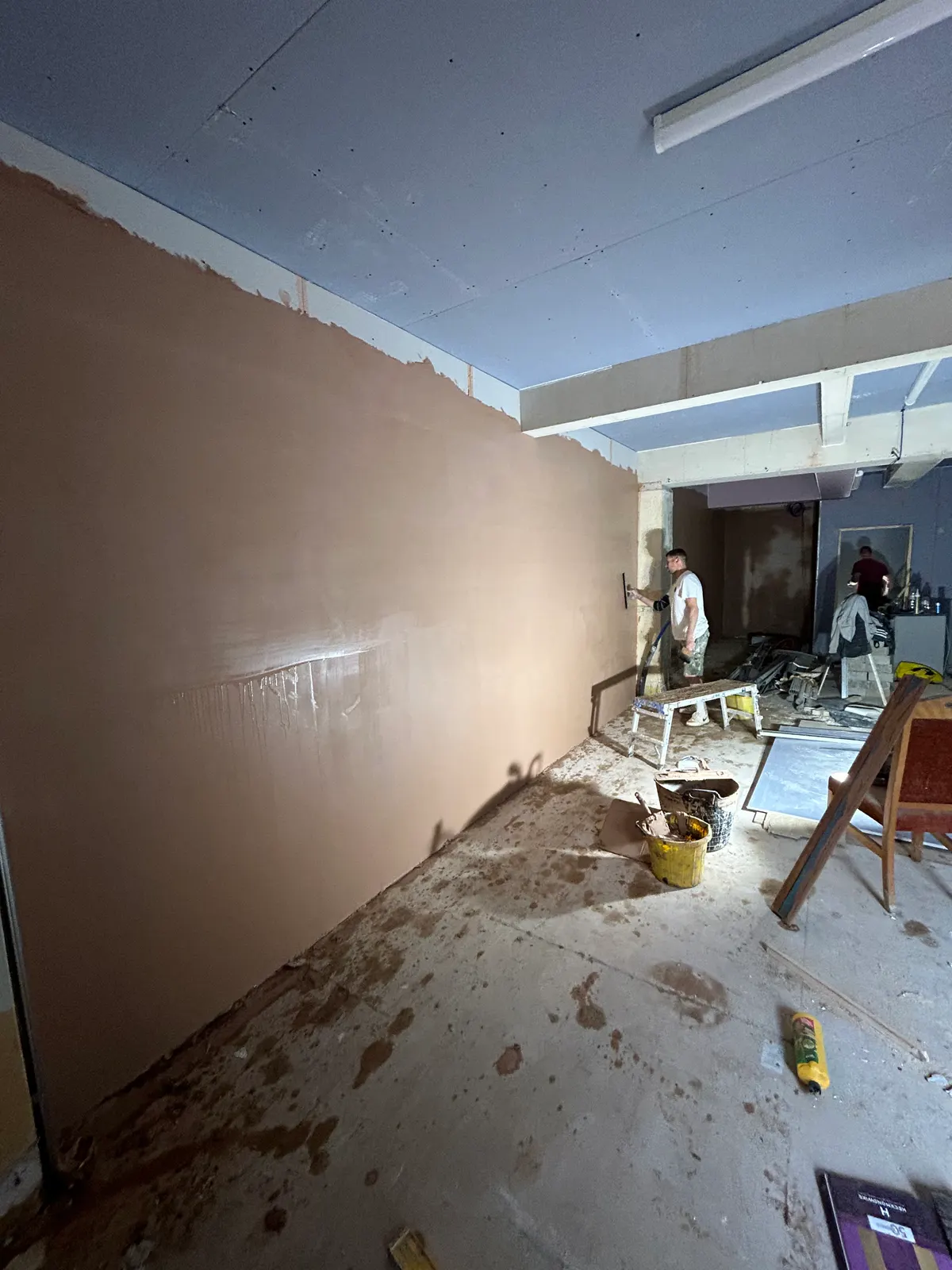 Freshly skimmed wall in a large open-plan room during renovation